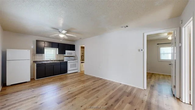 a kitchen with a refrigerator and a stove top oven