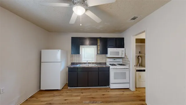 a kitchen with stainless steel appliances granite countertop a refrigerator a stove a sink and a microwave