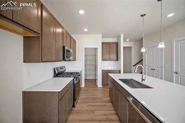 a kitchen with a sink stove and refrigerator