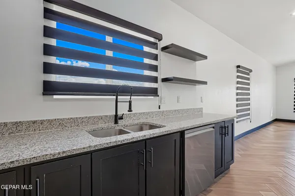 a kitchen with a sink and a wooden floor