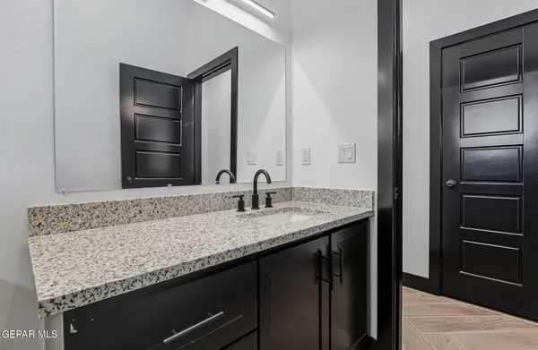 a bathroom with a granite countertop sink and a mirror