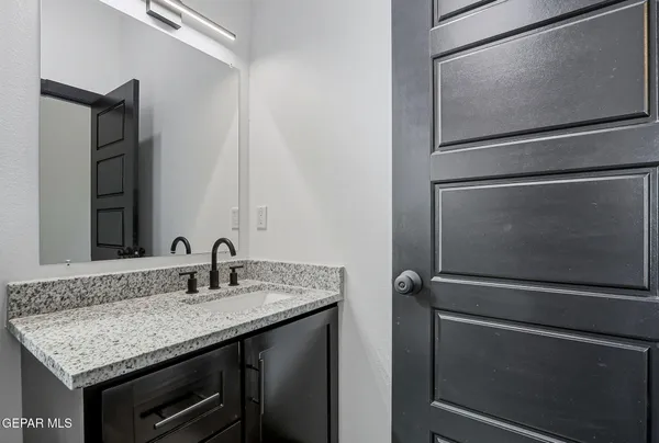 a bathroom with a granite countertop sink and a mirror