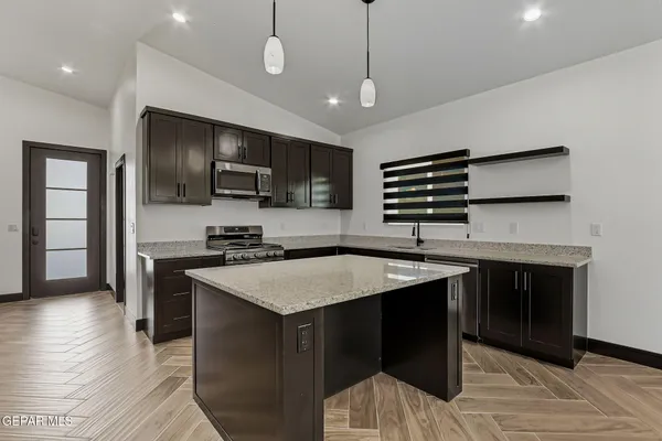 a kitchen with a center island appliances and cabinets