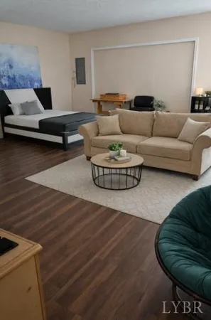 a living room with furniture and a wooden floor