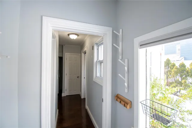 a view of a hallway with wooden floor and windows