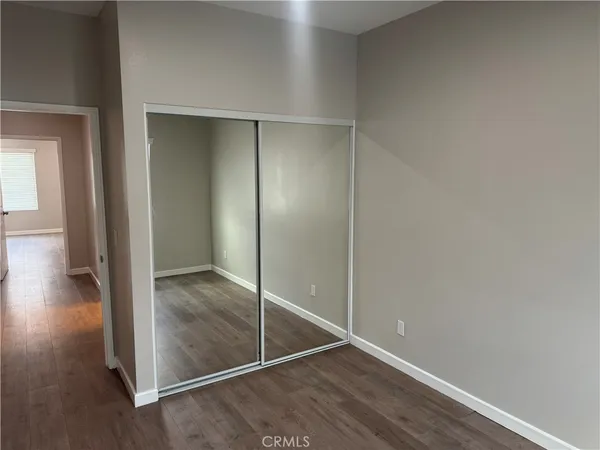 a view of empty room with wooden floor and window