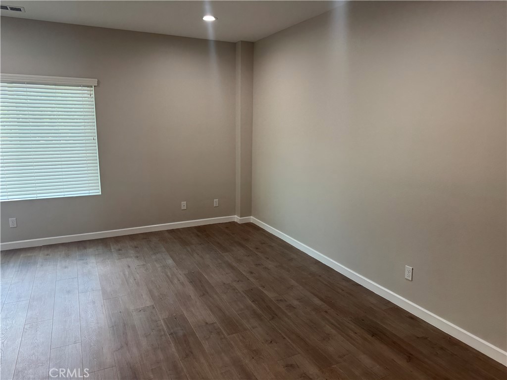 13665 Arrow Route, Unit 3 Fontana, CA 92335 - Photo 21 of 32 an empty room with wooden floor and windows