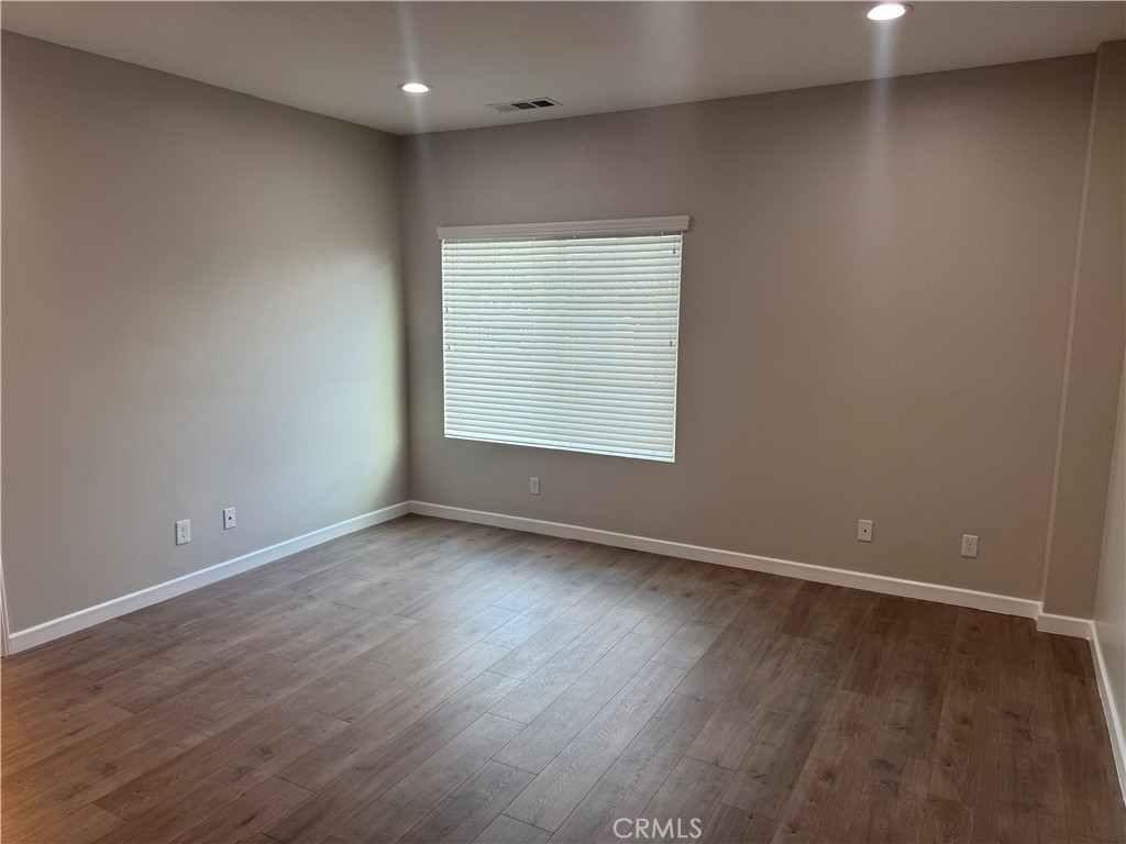 13665 Arrow Route, Unit 3 Fontana, CA 92335 - Photo 22 of 32 a view of an empty room with wooden floor and a window