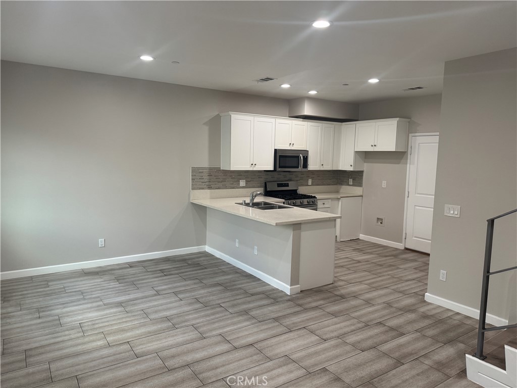 13665 Arrow Route, Unit 3 Fontana, CA 92335 - Photo 5 of 32 a kitchen with a refrigerator and a stove top oven