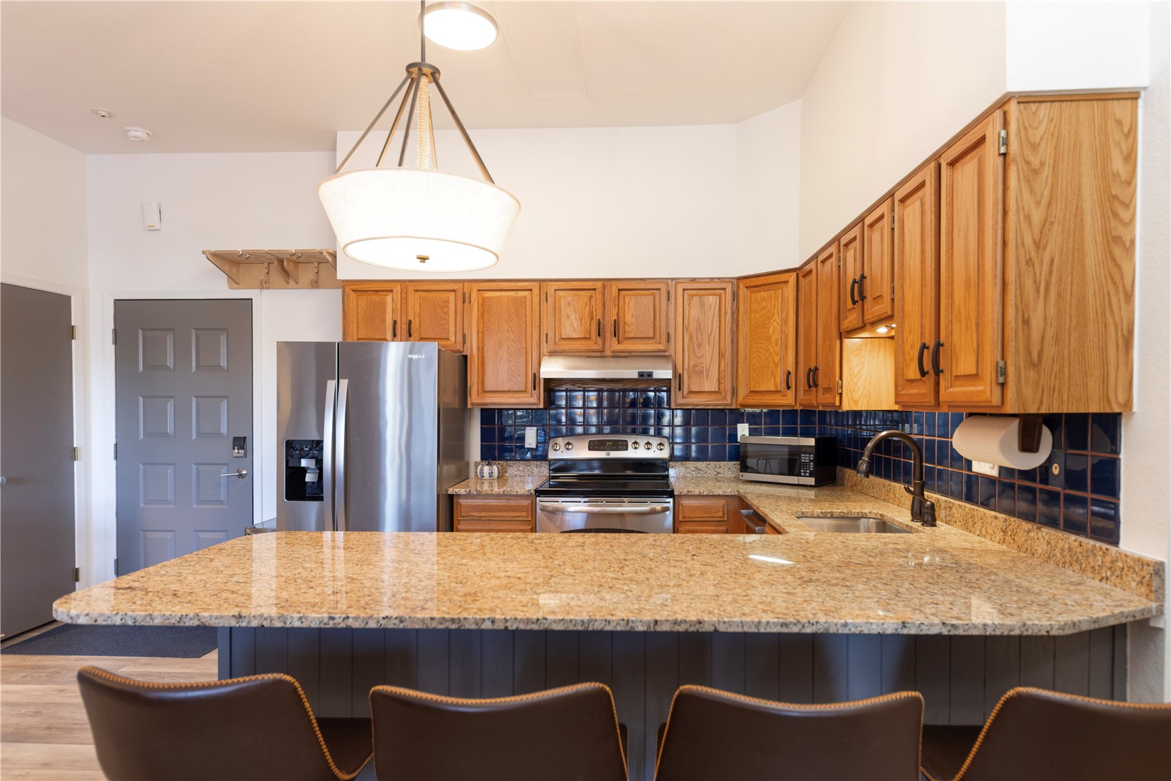 89410 Ryan Gulch Road, Unit 104 Silverthorne, CO 80498 - Photo 26 of 31 a kitchen with kitchen island granite countertop a table chairs sink and refrigerator