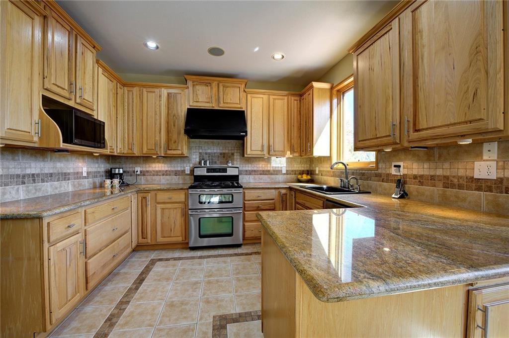 78 Double Tree Road Bailey, CO 80421 - Photo 12 of 34 a kitchen with stainless steel appliances granite countertop a stove sink microwave and cabinets