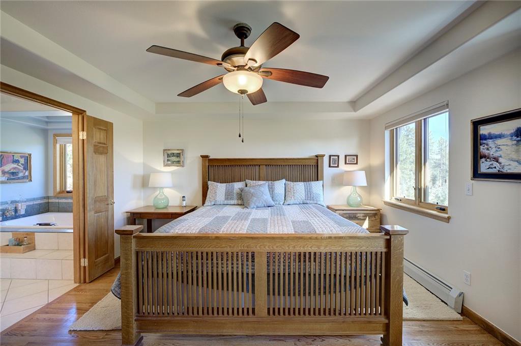 78 Double Tree Road Bailey, CO 80421 - Photo 16 of 34 a bedroom with a bed and a chandelier