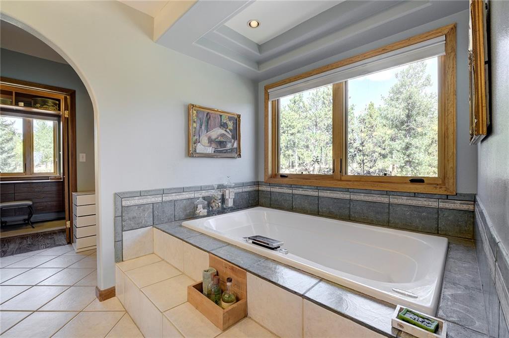 78 Double Tree Road Bailey, CO 80421 - Photo 18 of 34 a bathroom with a tub a sink and a large window