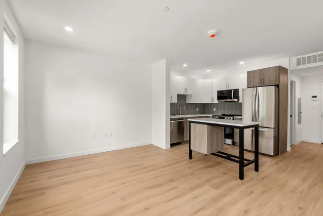 a view of kitchen with refrigerator microwave and wooden floor