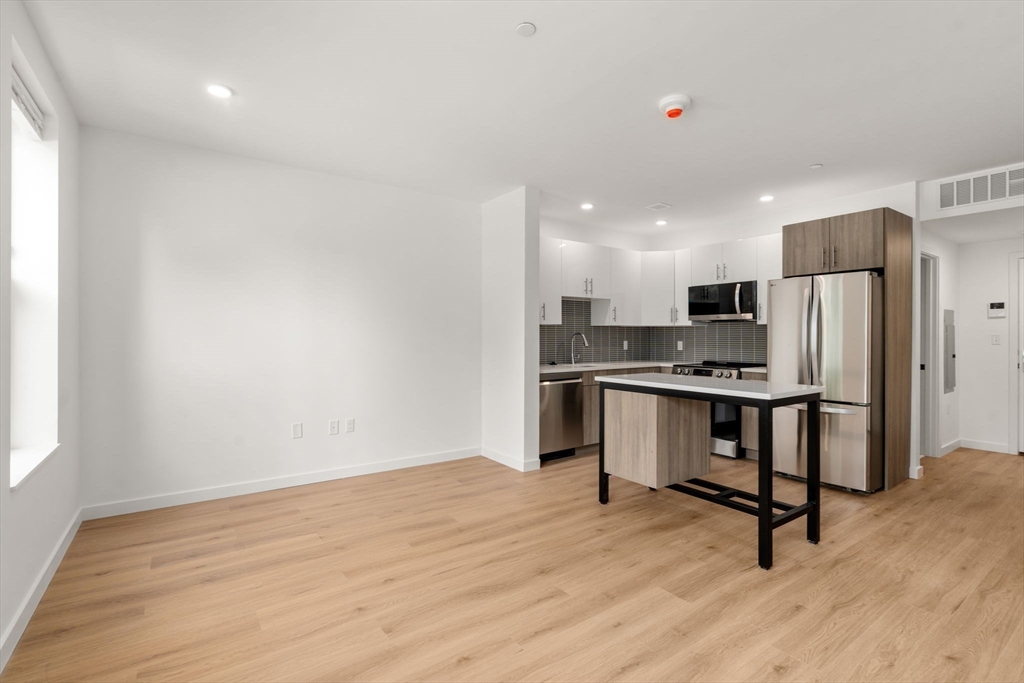 a view of kitchen with refrigerator microwave and wooden floor