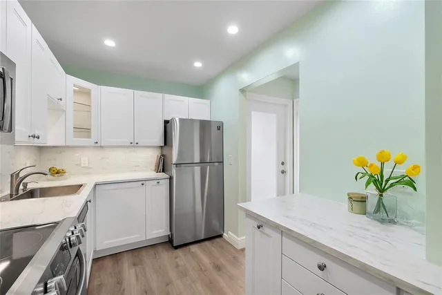 a kitchen with a sink a refrigerator and cabinets