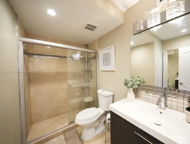 a bathroom with a sink mirror toilet and shower