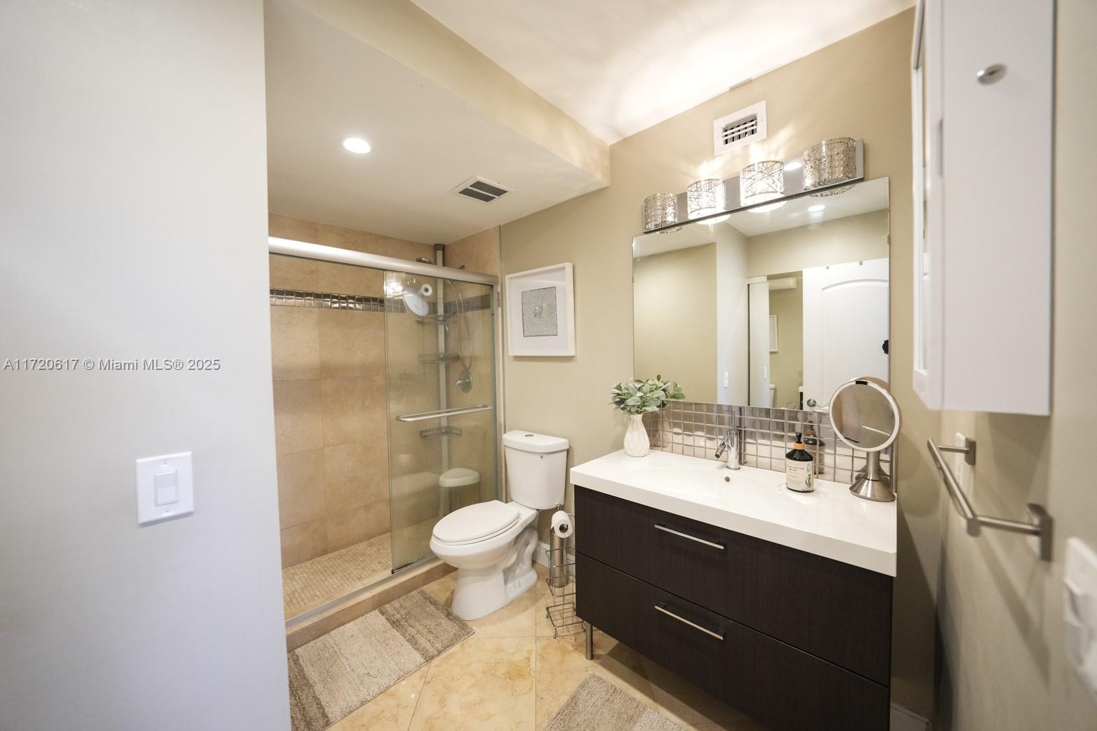200 Diplomat Parkway, Unit 827 Hallandale Beach, FL 33009 - Photo 12 of 26 a bathroom with a sink mirror toilet and shower