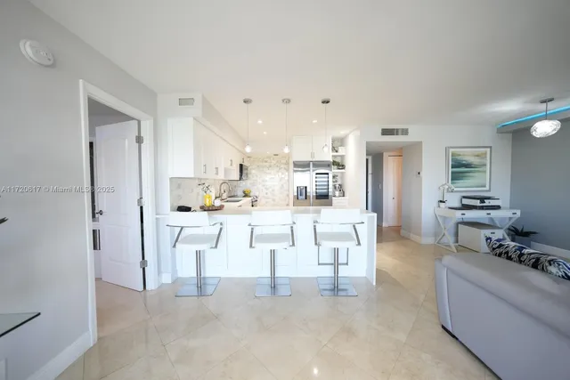 a living room with white cabinets and couches with wooden floor