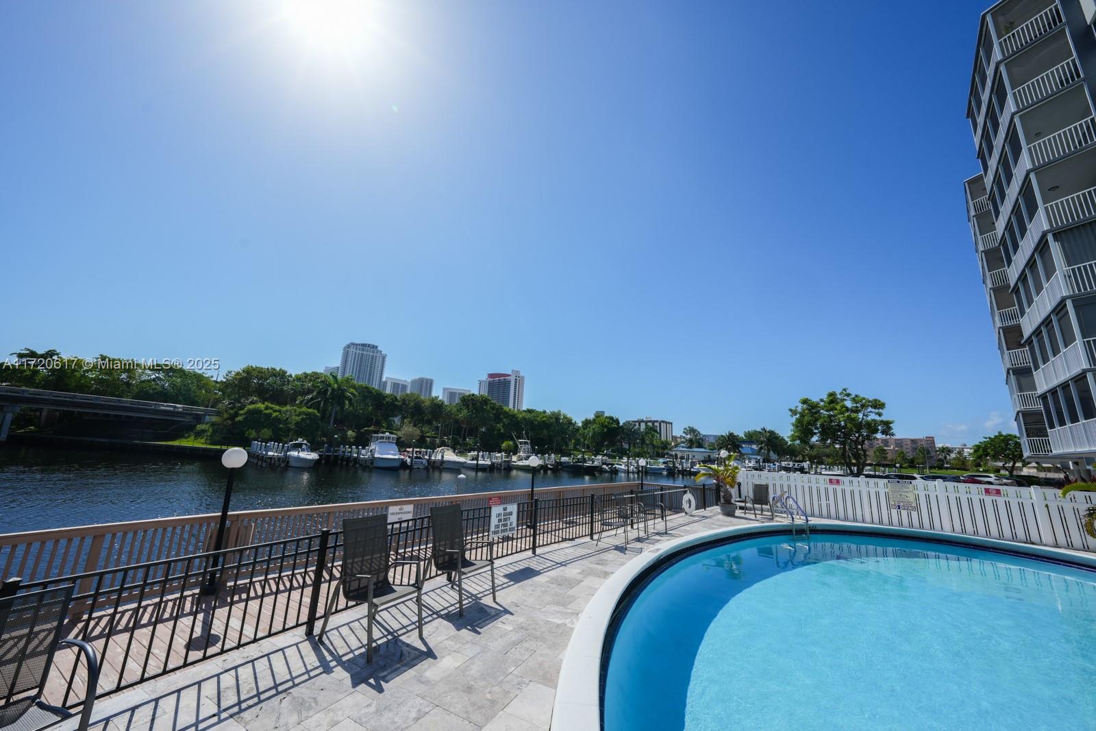200 Diplomat Parkway, Unit 827 Hallandale Beach, FL 33009 - Photo 7 of 26 a view of a lake with a terrace next to a yard