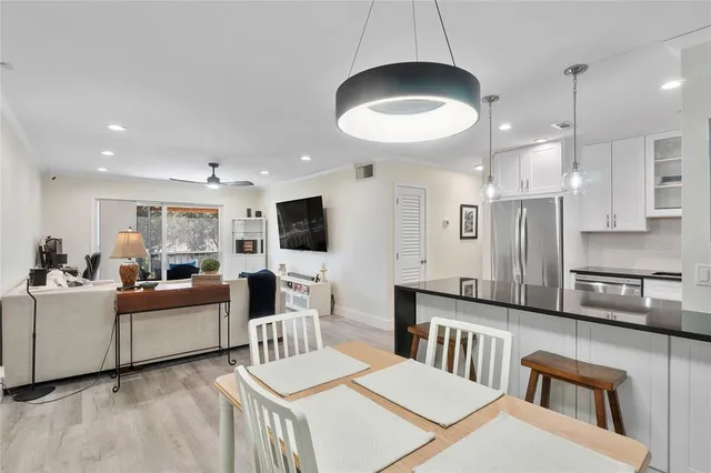 a living room with furniture a flat screen tv and kitchen view
