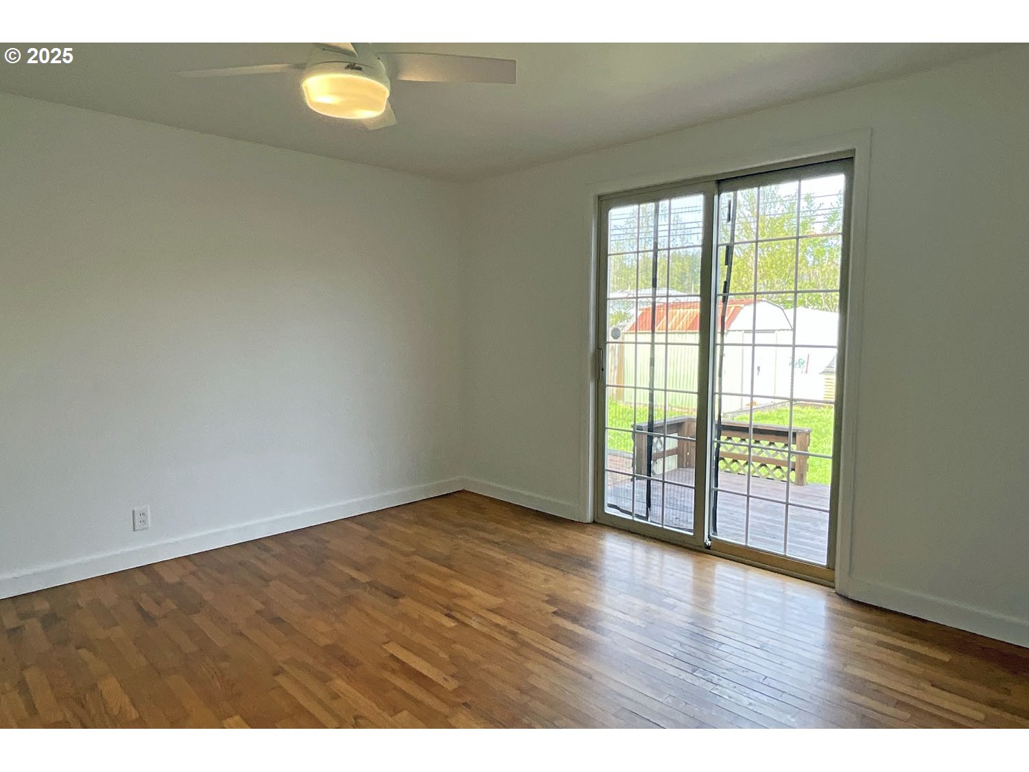 2775 Hilyard Street Eugene, OR 97405 - Photo 8 of 27 a view of an empty room with a window and wooden floor