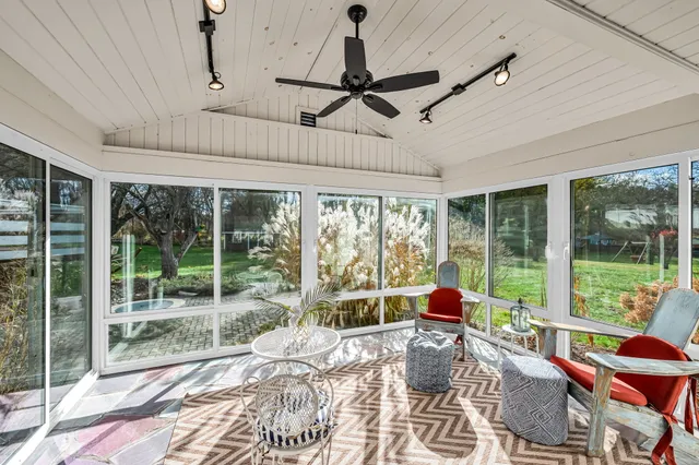 a living room with patio furniture and a floor to ceiling window