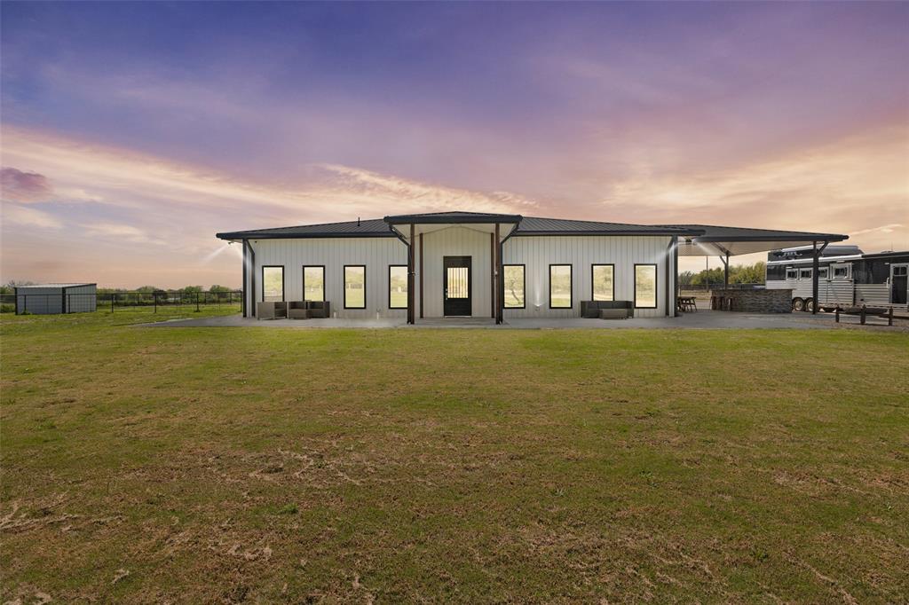 a front view of house with yard and lake view