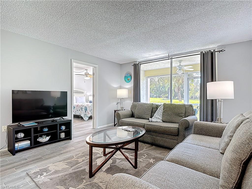 200 Turtle Lake Court, Unit 109 Naples, FL 34105 - Photo 14 of 37 a living room with furniture and a flat screen tv