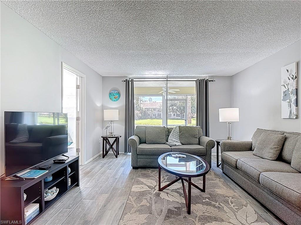200 Turtle Lake Court, Unit 109 Naples, FL 34105 - Photo 15 of 37 a living room with furniture and a flat screen tv