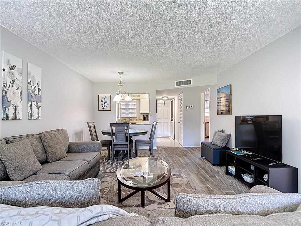 200 Turtle Lake Court, Unit 109 Naples, FL 34105 - Photo 18 of 37 a living room with furniture and a flat screen tv