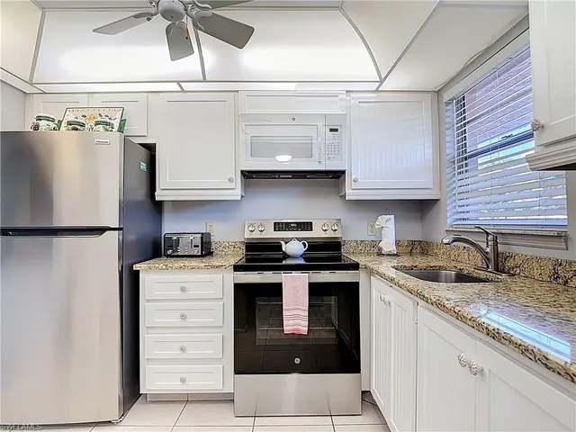 a kitchen with stainless steel appliances granite countertop a sink and a stove