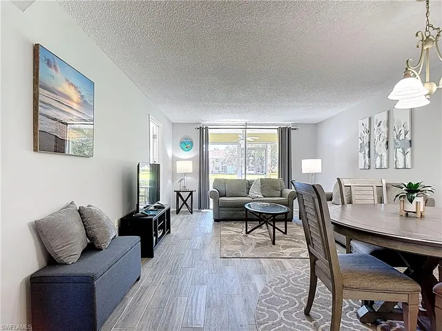 a living room with furniture wooden floor and a window