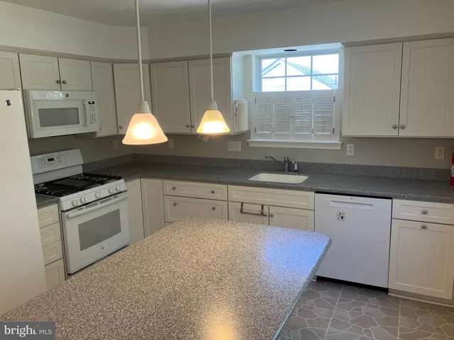 a kitchen with stainless steel appliances granite countertop a sink a stove and a microwave