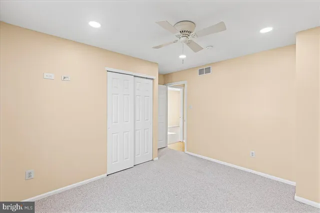an empty room with a ceiling fan and a window
