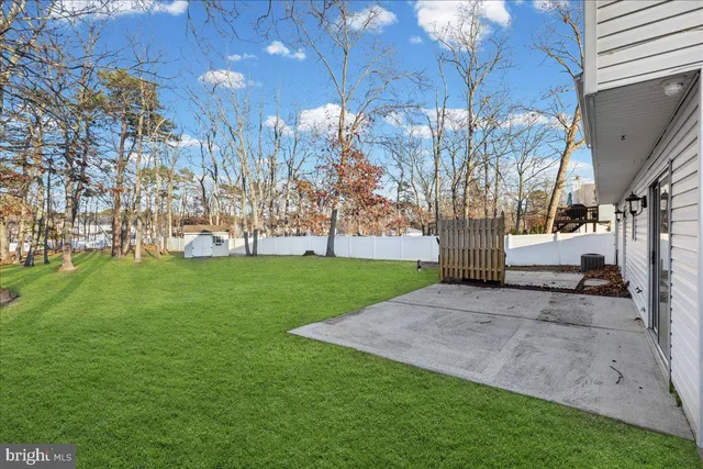 a view of a house with a big yard with large tree and wooden fence