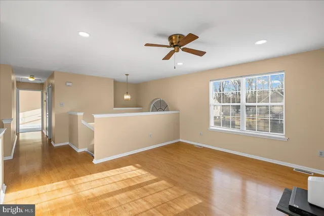 a view of a livingroom with a flesh screen tv and wooden floor