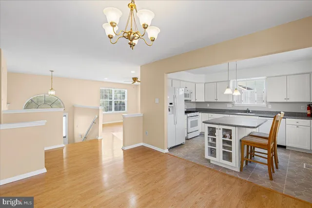 a kitchen with stainless steel appliances a dining table chairs and chandelier