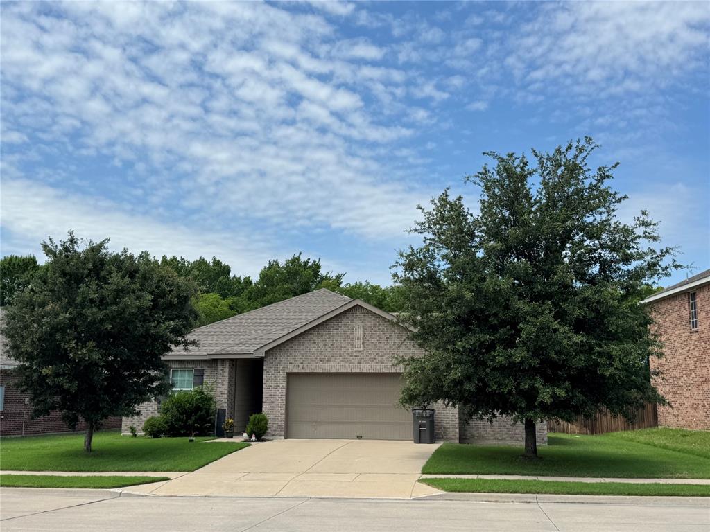 2209 Cinnamon Spgs Road Glenn Heights, TX 75154 - Photo 1 of 28 Brick-front residence featuring a two-car garage, pitched shingle roof, concrete driveway, and mature landscaping
