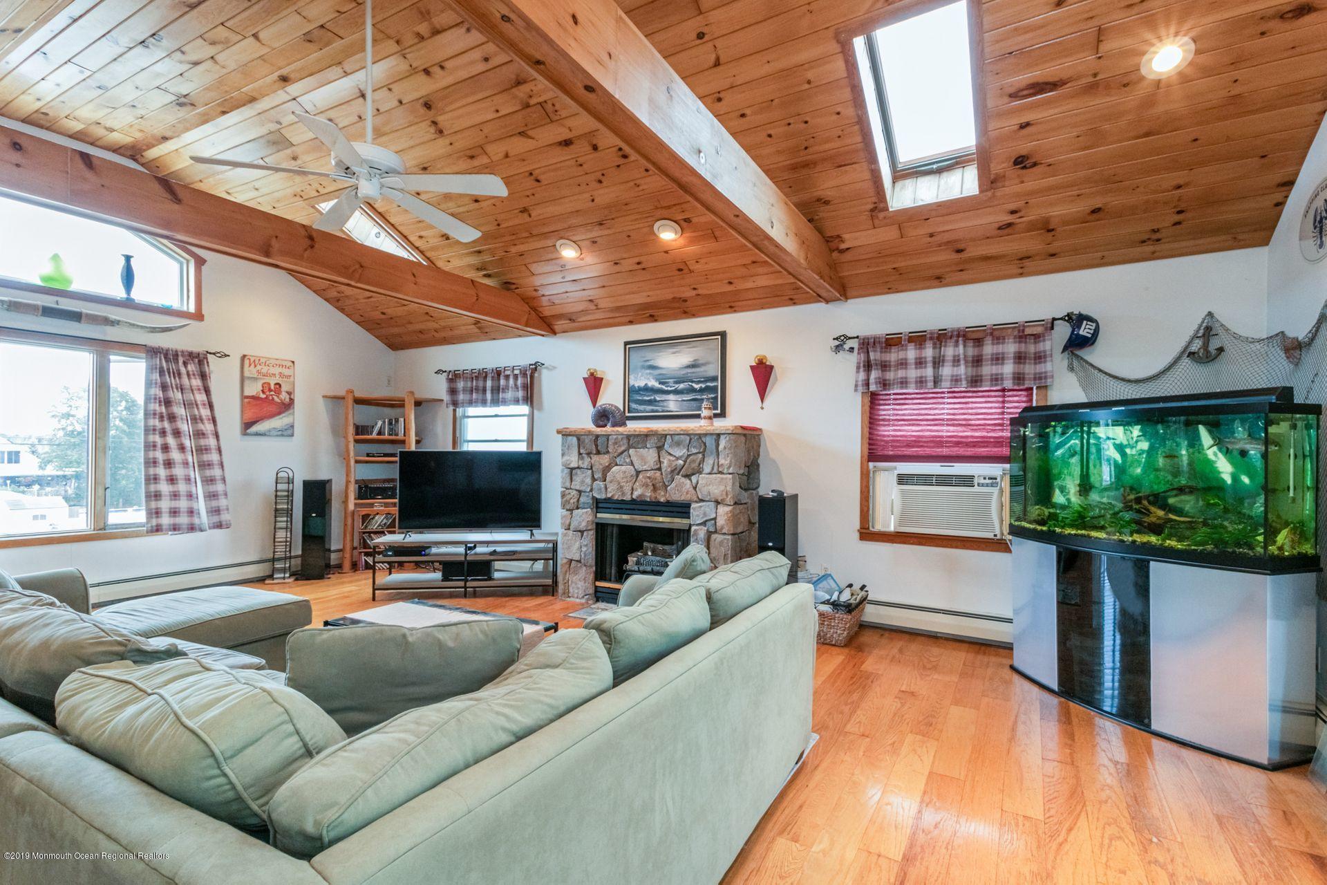 132 Mizzen Road Brick, NJ 08723 - Photo 25 of 41 a living room with furniture a fireplace and a flat screen tv
