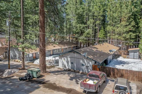 an aerial view of a house with outdoor space and trees all around