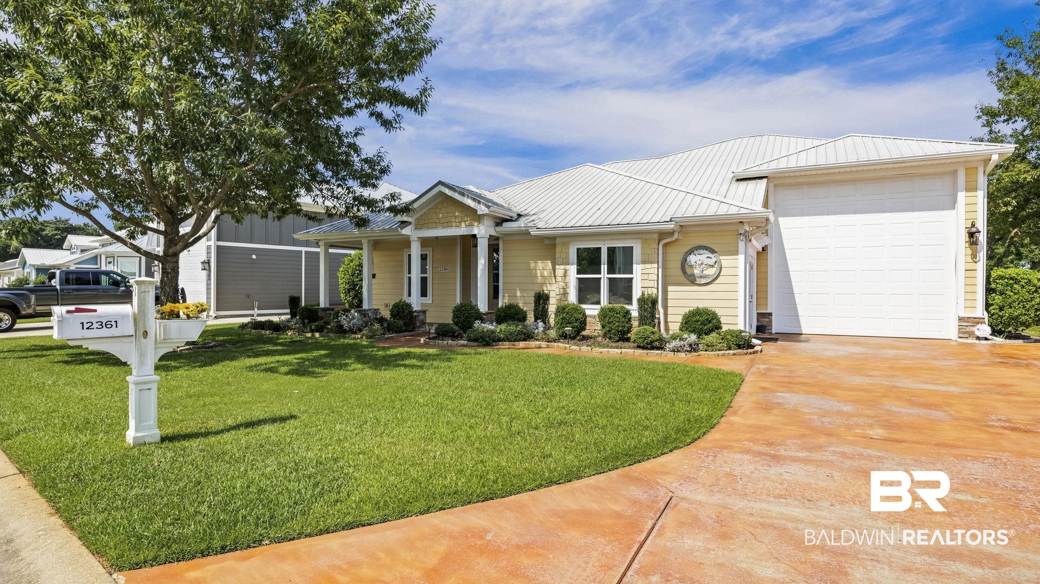12361 Reunion Place Foley, AL 36535 - Photo 4 of 43 View of front of house with a front lawn, driveway, a metal roof, an attached garage, and a porch