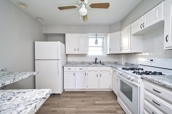 54 Grinnell Street, Unit 1 Fall River, MA 02721 - Photo 3 of 7 a kitchen with stainless steel appliances granite countertop a stove a refrigerator a sink and white cabinets