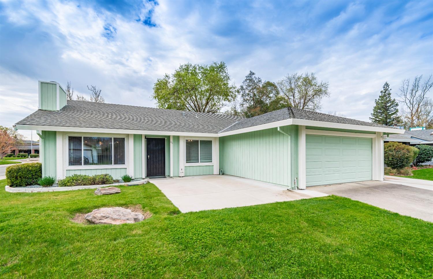a front view of a house with a garden and yard