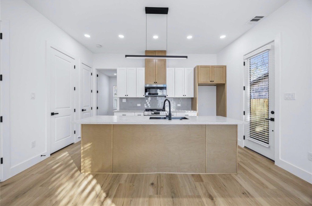 3923 Aledo Street, Unit B Houston, TX 77051 - Photo 5 of 12 a large kitchen with kitchen island a sink stainless steel appliances and cabinets