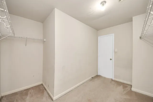 an empty room with windows and ceiling fan