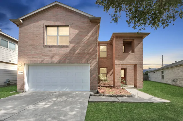 a front view of a house with a garden and yard