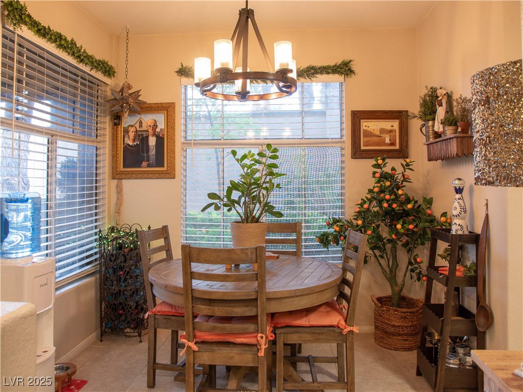 2050 West Warm Springs Road, Unit 411 Henderson, NV 89014 - Photo 11 of 30 Dining space with baseboards, light tile patterned flooring, and a chandelier