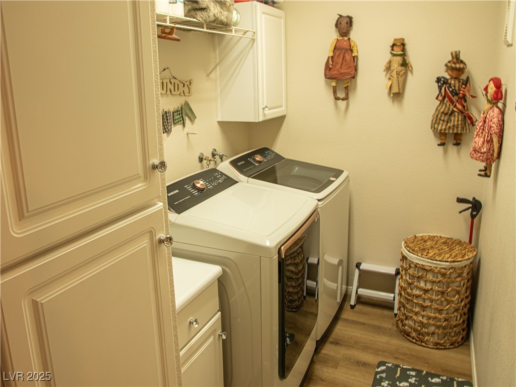 2050 West Warm Springs Road, Unit 411 Henderson, NV 89014 - Photo 14 of 30 Laundry room featuring separate washer and dryer, cabinet space, and wood finished floors