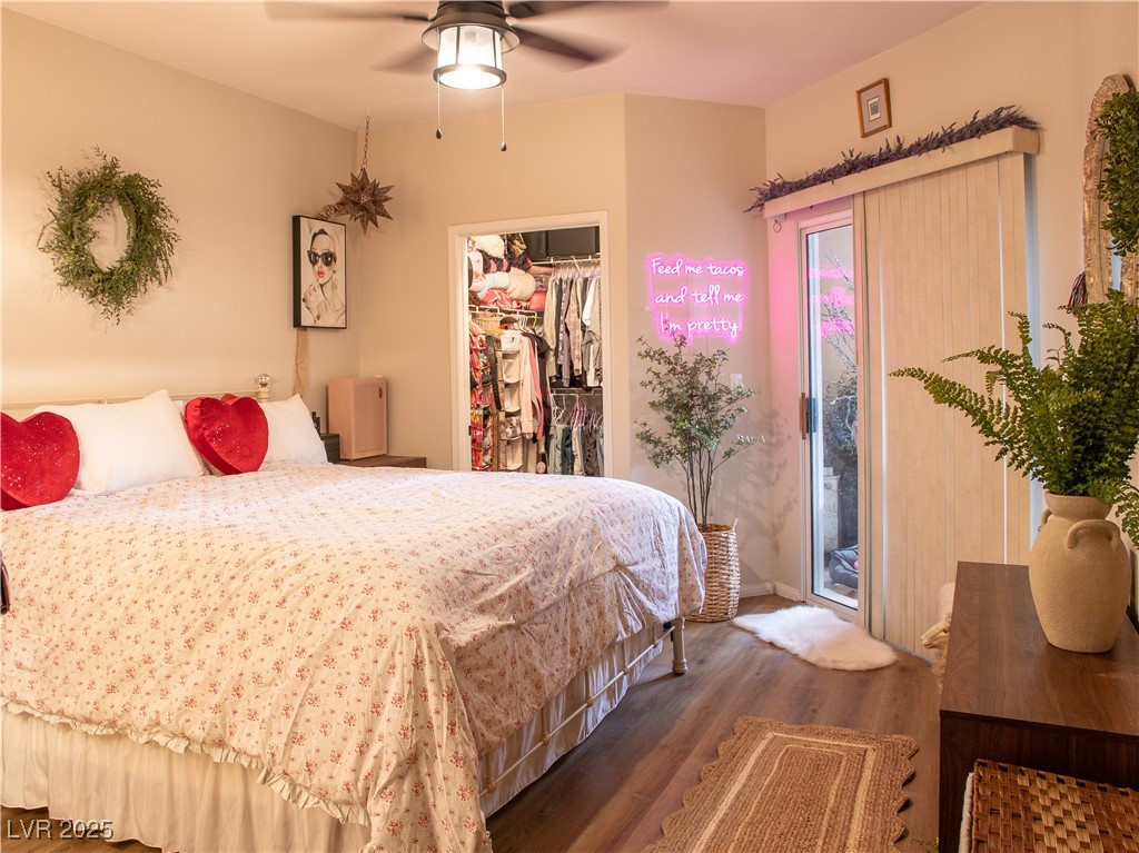 2050 West Warm Springs Road, Unit 411 Henderson, NV 89014 - Photo 15 of 30 Bedroom with access to outside, a walk in closet, a ceiling fan, wood finished floors, and a closet